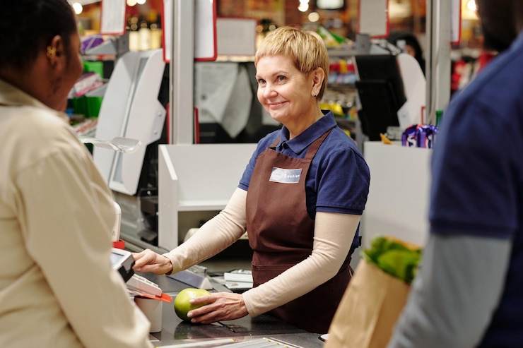 Photo happy blond mature cashier looking at african american woman