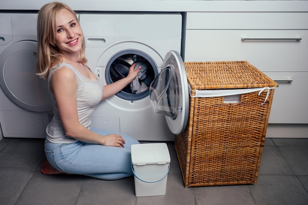 happy blonde female washing clothes feeling happy about soft fresh laundry aroma fabric softener aromatherapy