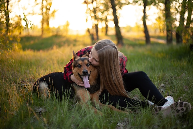 Happy blonde girl is played with a dog.