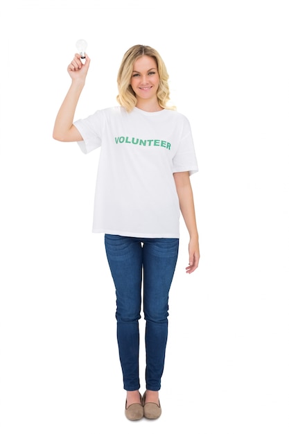 Happy blonde volunteer holding light bulb