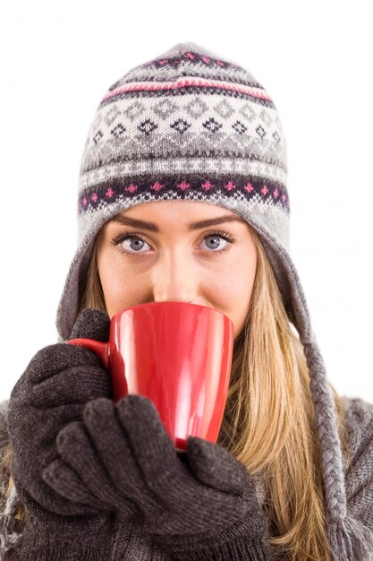 Happy blonde in winter clothes holding mug