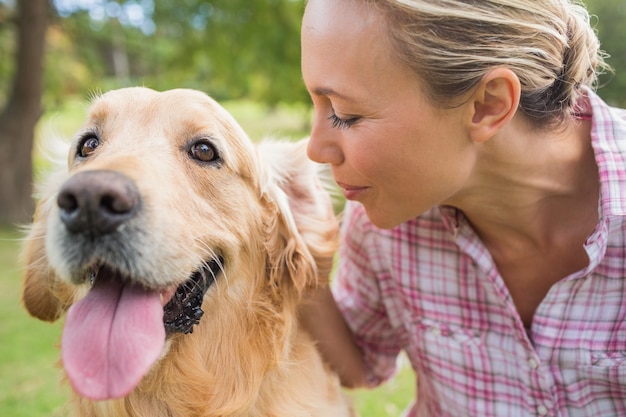 Happy blonde with her dog in the park 