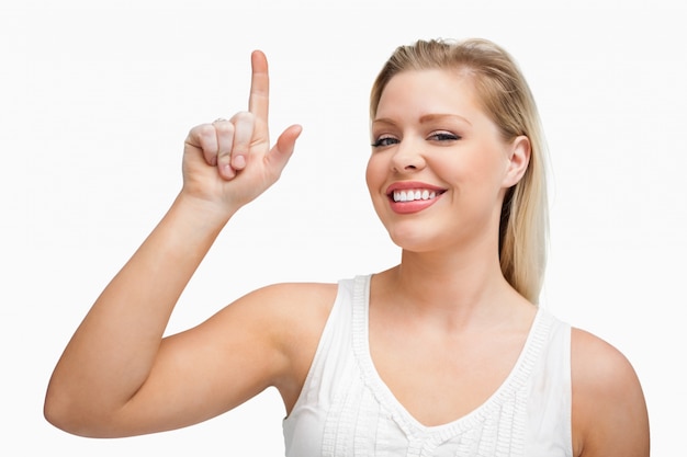 Photo happy blonde woman pointing her finger up