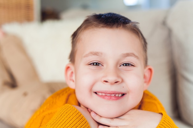 Felice ragazzo di 6 anni sta riposando sul divano.