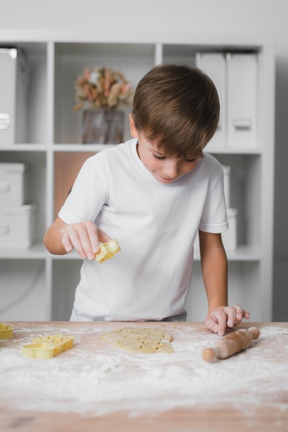 Happy boy child preparing homemade cookies.