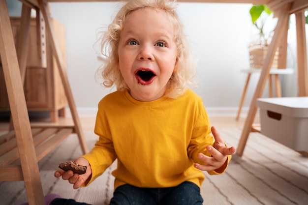 Photo happy boy eating sweets on chocolate day