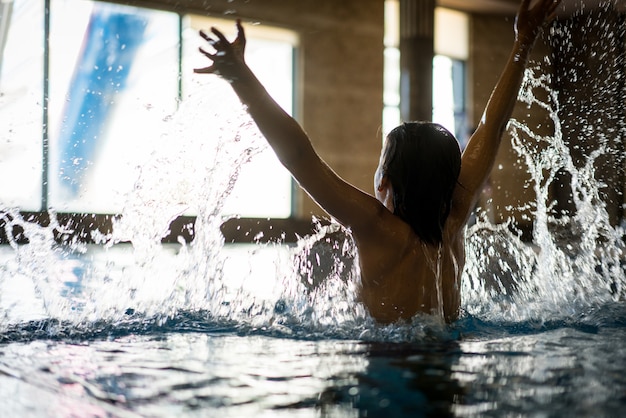 Foto il ragazzo felice gode di di nuotare in piscina