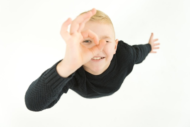 The happy boy gesture to the camera. View from above