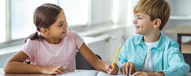 The happy boy and a girl doing homework at the desk