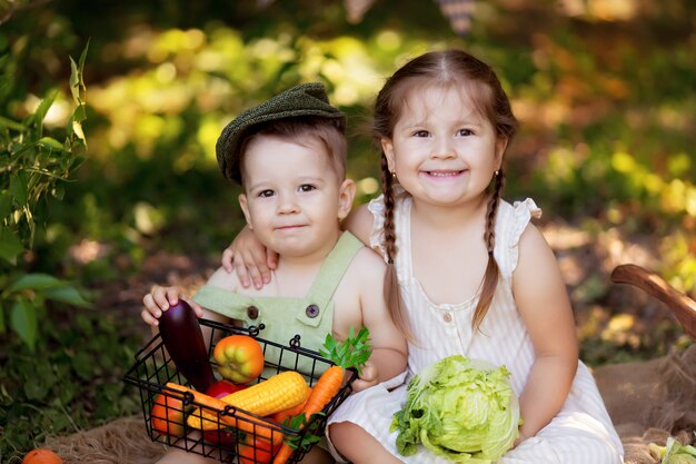 幸せな男の子と女の子の自然の中で野菜のサラダを準備