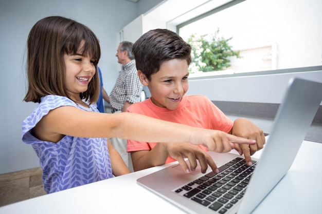 Photo happy boy and girl using laptop