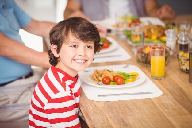 家族と一緒に朝食を食べて幸せな少年