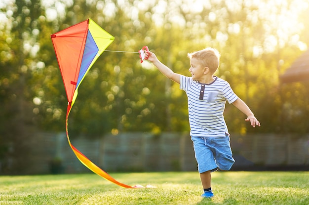 Photo happy boy having fun playing with kite