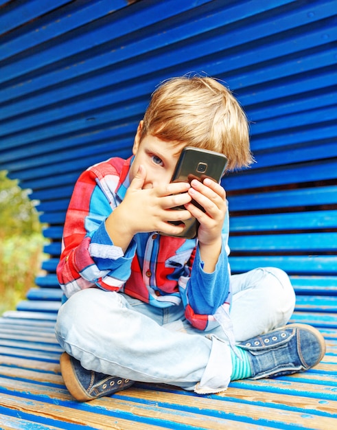 Happy boy having fun with a smartphone