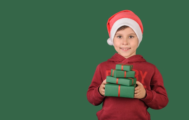 Happy boy holding a gift on a green background