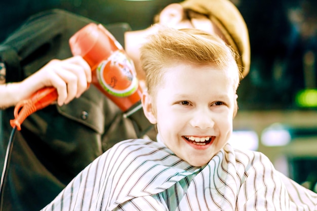 Happy boy kid in barber salon