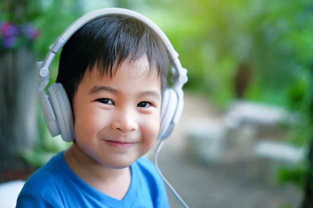 Happy Boy kid listen music with headphone at home. Smile face portrait image.