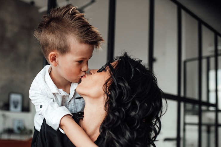 Photo happy boy kissing mother