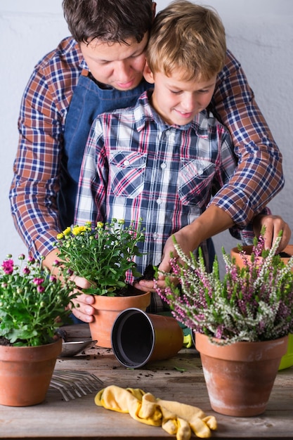 鉢の植物を見ている幸せな少年