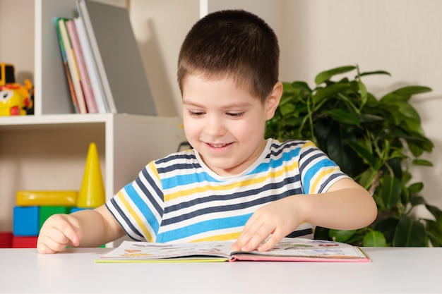 A happy boy looks at a book with pictures