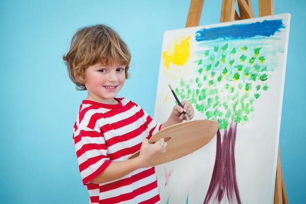 Happy boy painting his picture