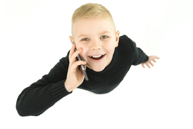 The happy boy phone on the white background. View from above