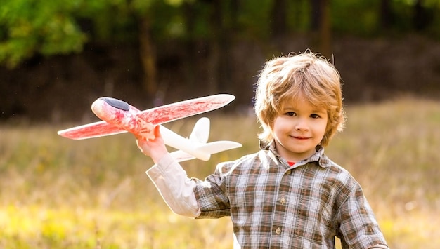 Happy boy play airplane. Little boy with plane. kid dreams of being a pilot