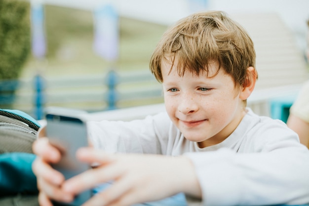 携帯電話で遊んで幸せな少年