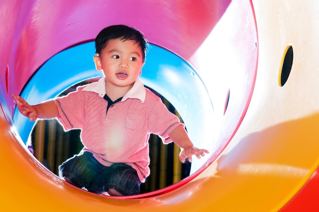 Happy boy playing in slide at amusement park