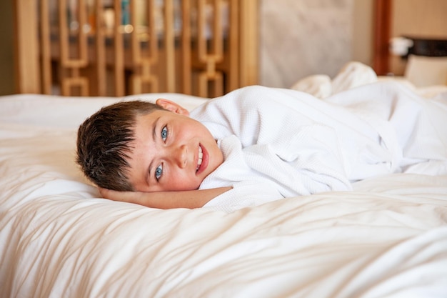 Happy boy recently awaken at luxury hotel room