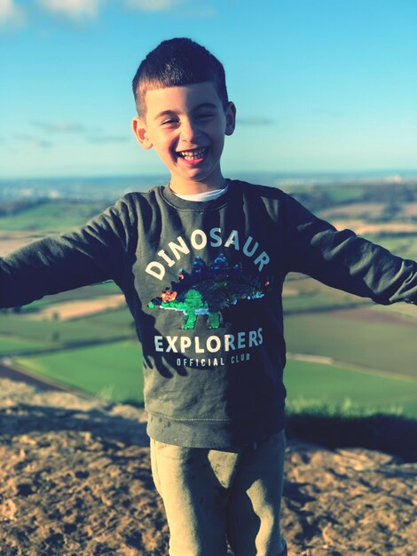 Photo happy boy rewarded with view after hill climbing