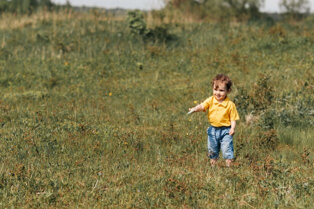 Happy boy runs outdoors with a kite