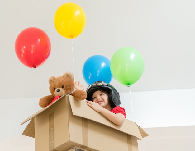 Happy boy sitting in his box imagining himself flying