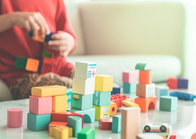 写真 教育玩具用のリビングルームにおもちゃのブロックをスタッキング幸せな少年
