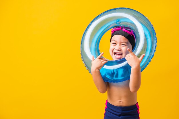 Happy boy standing against yellow background