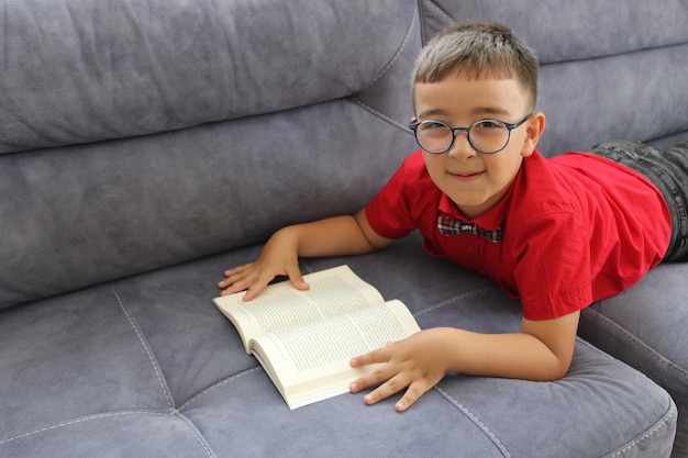 happy boy student reading a book lying down