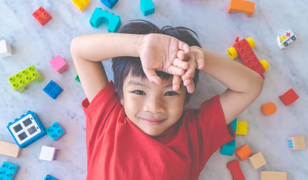 Happy boy surrounded by colorful toy blocks