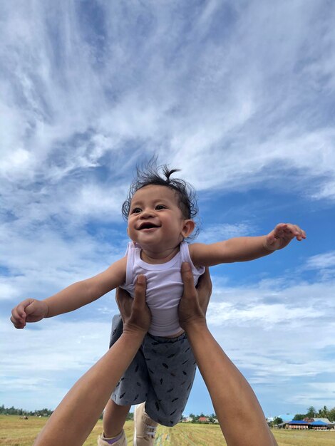 Foto ragazzo felice con le braccia alzate contro il cielo