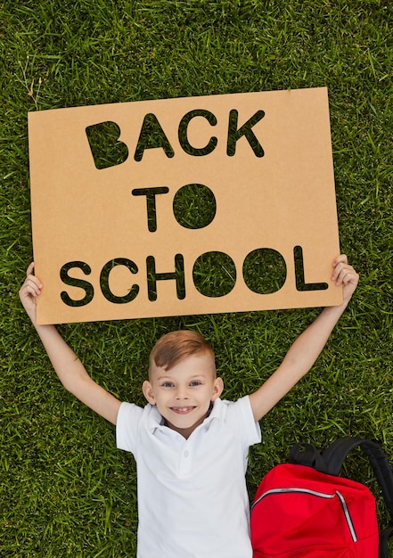 Photo happy boy with back to school poster