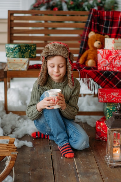 クリスマスに温かい飲み物と幸せな少年