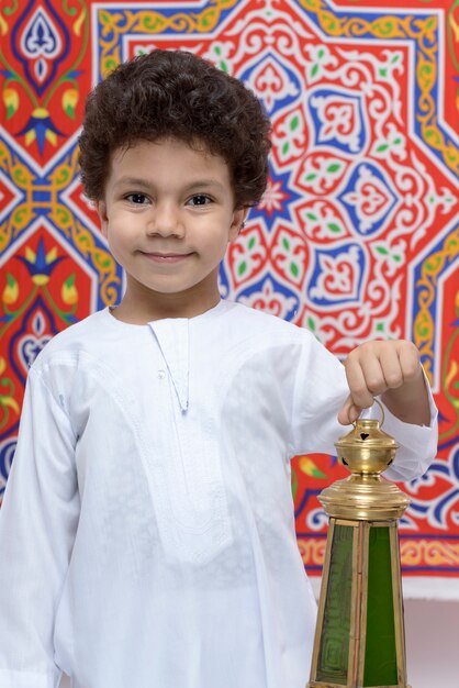 Foto ragazzo felice con lanterna che celebra il ramadan