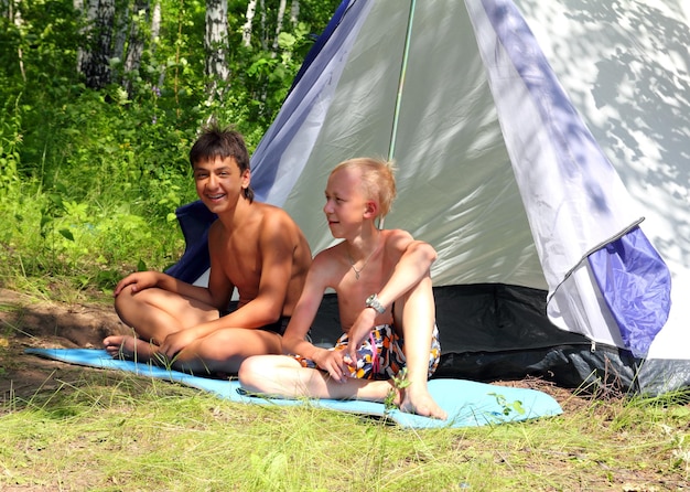 Happy boys near camping tent