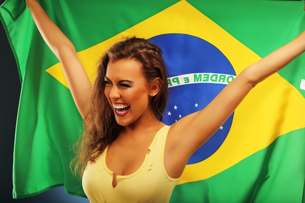 A happy Brazilian fan cheering with flag