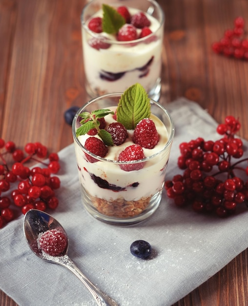 Happy breakfast yoghurt met muesli en bessen op een houten tafel