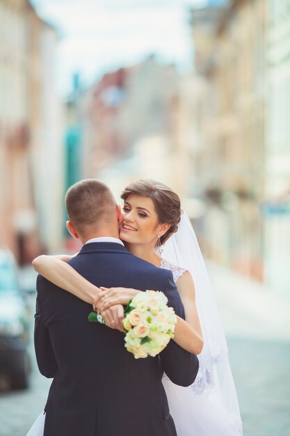 Happy bride and groom dancing on street