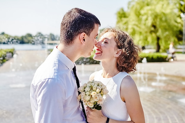 Happy bride and groom hug in the park