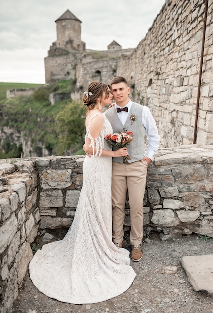 Happy bride and groom on their wedding near old castle