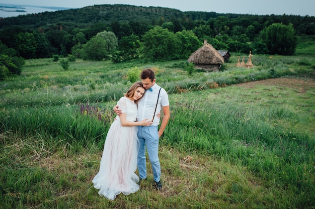 Happy Bride and groom walking on the green grass