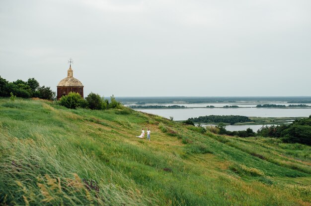 Happy Bride and groom walking on the green grass