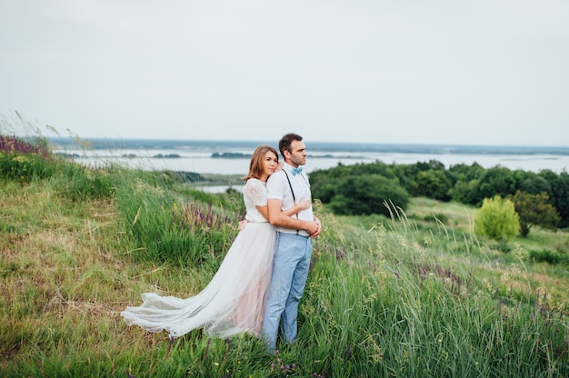 Happy Bride and groom walking on the green grass